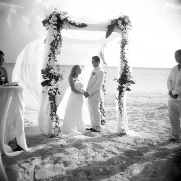 photo by New York City based wedding photographer Karen Hill - beautiful black and white image of beach ceremony with floral altar 